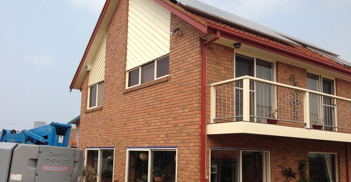 A double-storey brick home with freshly painted trims, balcony and window frames