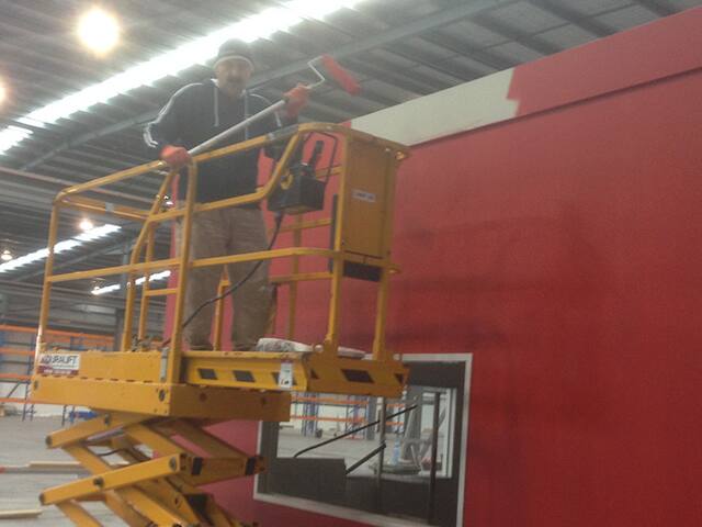 Factory interior feature wall. Interior walls in an industrial space, painted from a scissor lift.